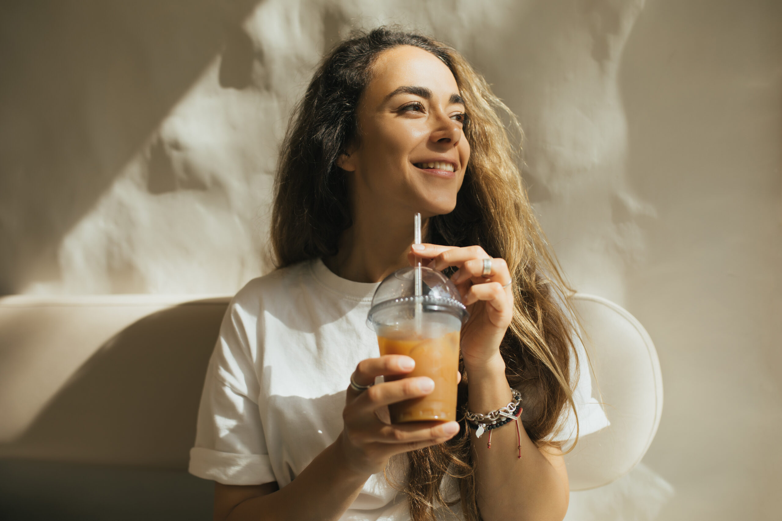 Gen Z woman sips an expensive coffee.